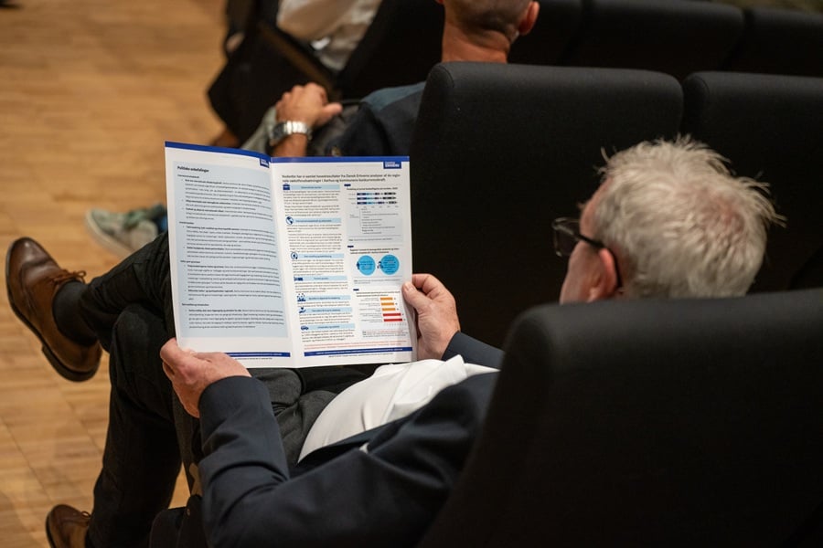 Mand læser i rapport fra Dansk Erhverv