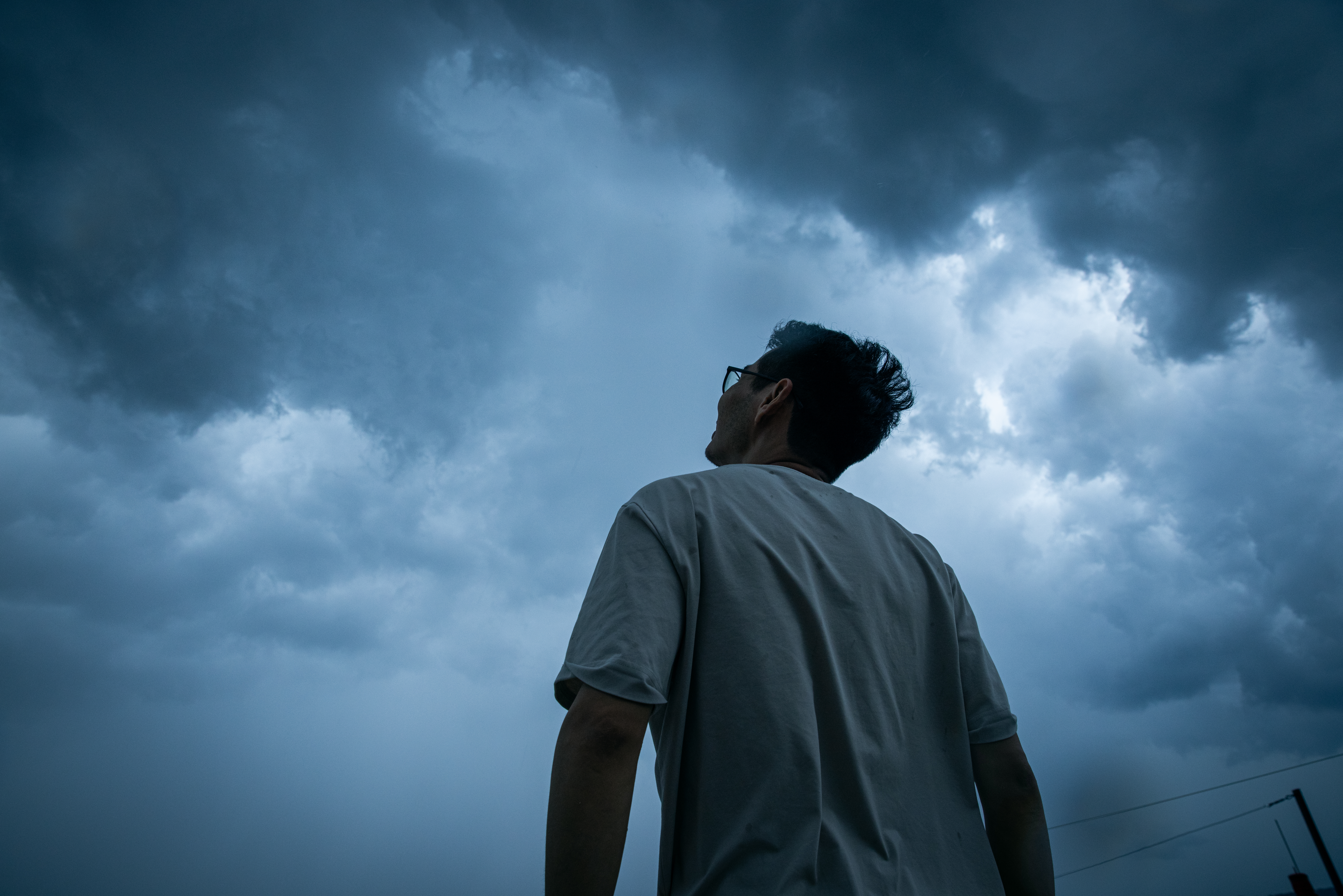 Mand kigger p&aring; stormvejrsskyer p&aring; himlen