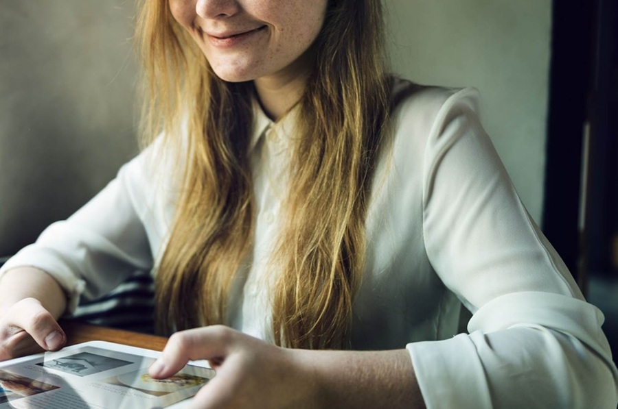 Kvinde, der sidder og browser p&aring; sin tablet