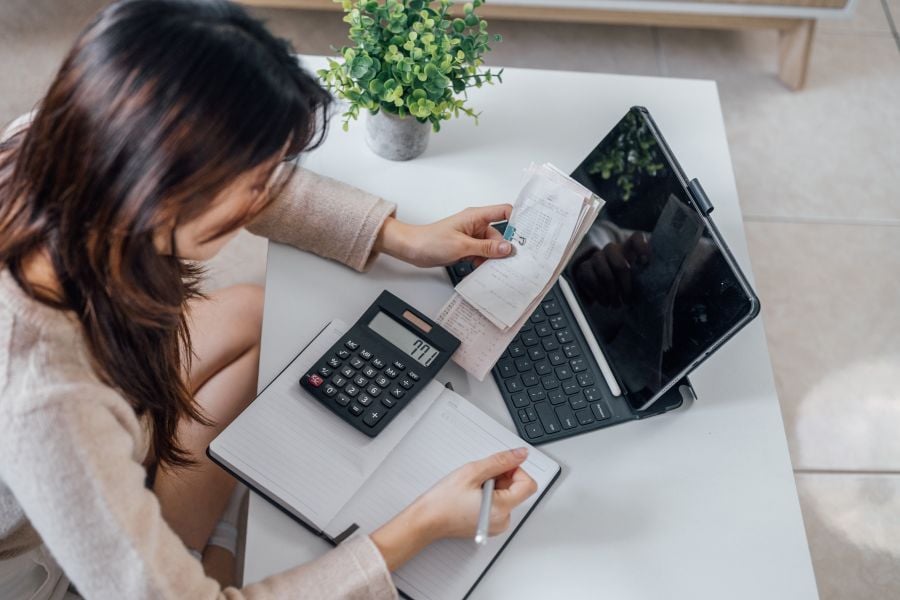 Dame ved skrivebord med lommeregner