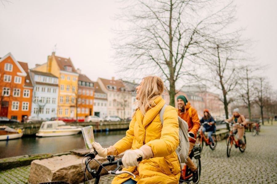 Turister cykler ved Nyhavn i K&oslash;benhavn