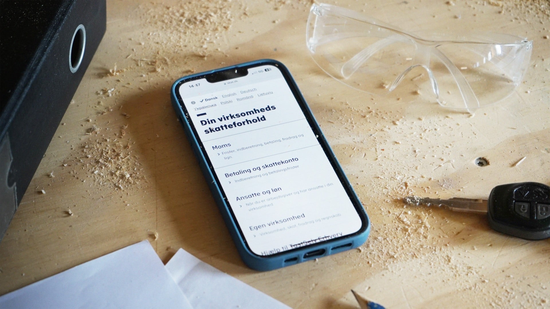 En mobil p&aring; skat.dk's hjemmeside ligger p&aring; et skrivebord
